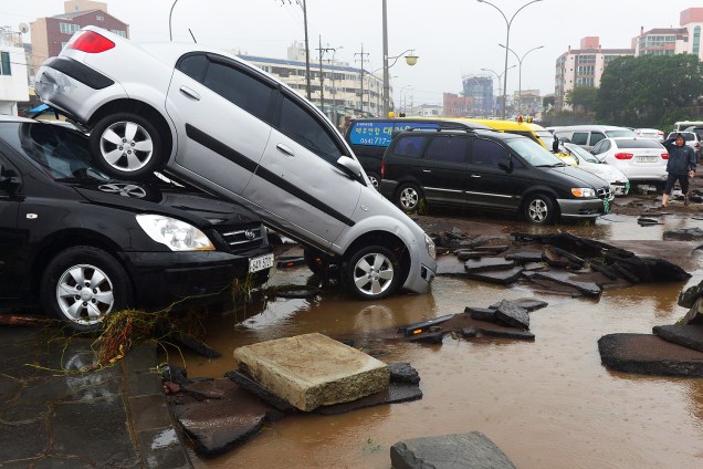 Carros arrastados por enchente provocada pela passagem do tufão Chaba são fotografados em rua da ilha de Jeju, na Coreia do Sul - 05-10-2016