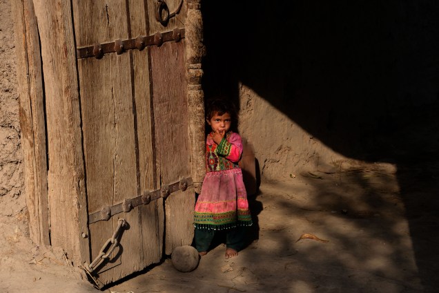 Garota afegã olha fotógrafo após receber vacina de pólio, durante campanha de vacinação na cidade de Jalalabad, no Afeganistão - 17/10/2016