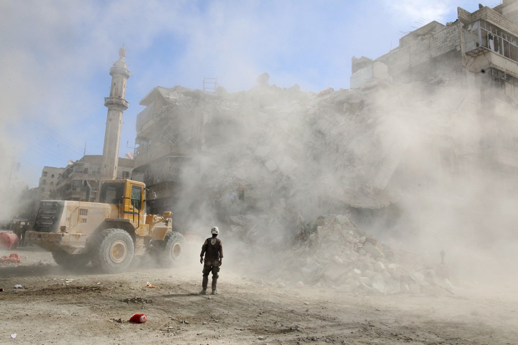 Membro da defesa civil ajuda na remoção de destroços após ataques aéreos que atingiram a região do último domingo (16), em Aleppo, Síria