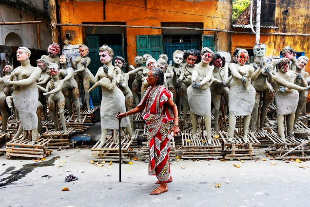 Mulher caminha próxima a estátuas inacabadas durante o Festival Kali Puja, em Calcuta, na Índia - 24/10/2016