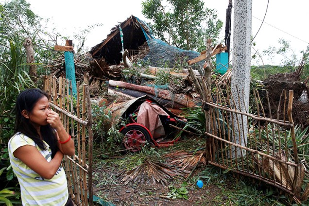 Mulher observa sua casa destruída após a passagem do tufão Haima, em Bangui, no norte das Filipinas - 20/10/2016