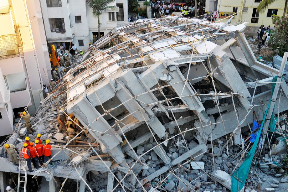 Policiais e equipes de resgate procuram sobreviventes após a queda de edifício em construção na cidade de Bangalore, na Índia - 05/10/2016