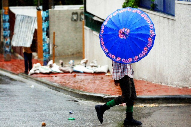 Pedestre se protege de ventania durante a passagem do furacão Matthew em Porto Príncipe, capital do Haiti - 04/10/2016