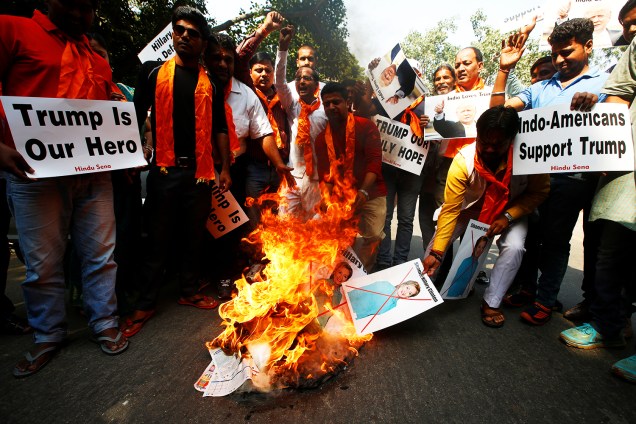 Membros do grupo Hindu Sena queimam cartazes da candidata à presidência dos Estados Unidos, Hillary Clinton, em protesto realizado na cidade de Nova Déli, na Índia - 18/10/2016