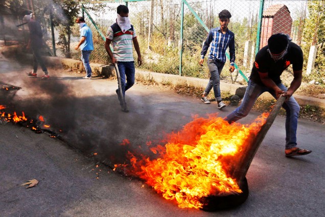 Manifestante queima pneu em protesto realizado na cidade de Srinagar, na região da Caxemira - 04/10/2016