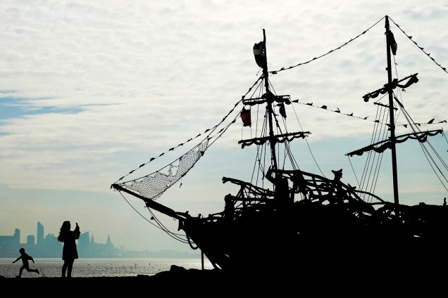 Turistas são vistos próximos a um navio pirata de madeira, em praia de New Brighton, na Grã-Bretanha - 25/10/2016
