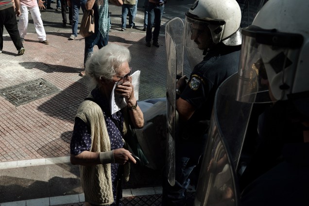 Idosa fica em frente a um bloqueio da polícia durante confrontos em uma manifestação de aposentados contra os cortes de pensão no centro de Atenas, na Grécia - 03/10/2016