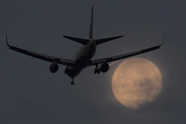 Avião se aproxima do aeroporto de Heathrow para aterrissagem, durante a superlua ao amanhecer no oeste de Londres - 17/10/2016