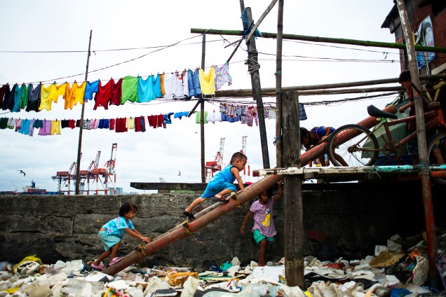 Crianças brincam em meio ao lixo, após a passagem do tufão Haima na Baía de Manila, nas Filipinas - 20/10/2016