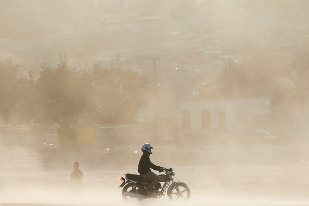 Homem dirige uma motocicleta em meio a uma tempestade de areia em Kabul, no Afeganistão - 18/10/2016