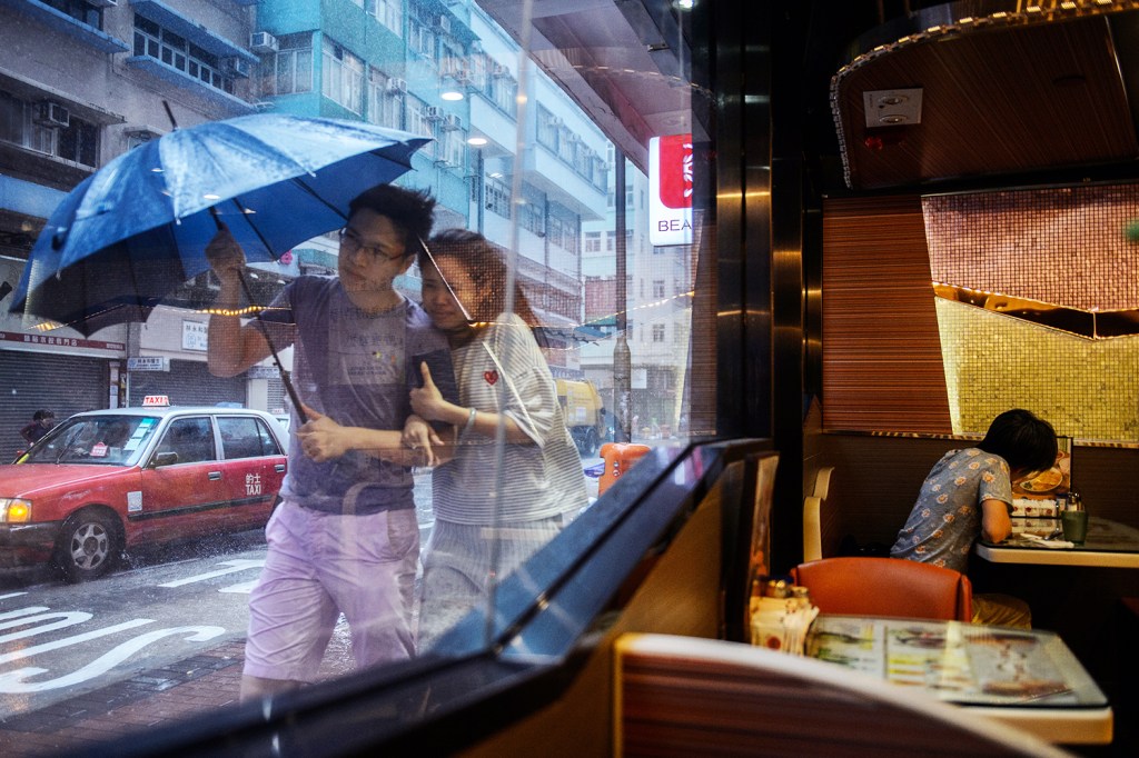 Casal caminha próximo de um restaurante durante a passagem do tufão Haima em Hong Kong, na China - 21/10/2016
