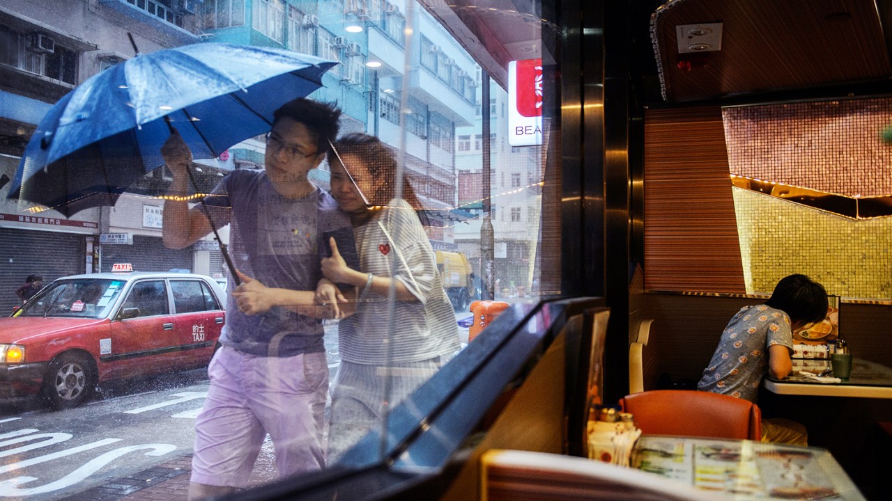 Casal caminha próximo de um restaurante durante a passagem do tufão Haima em Hong Kong, na China - 21/10/2016