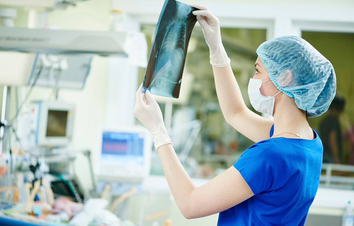 Médica observa exames de laboratório