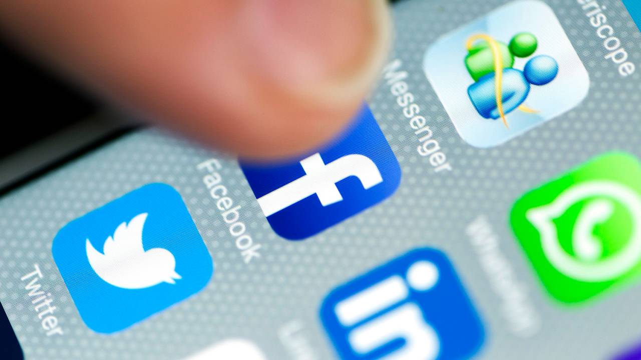 Male Finger is Touching Facebook App on iPhone 6 Screen