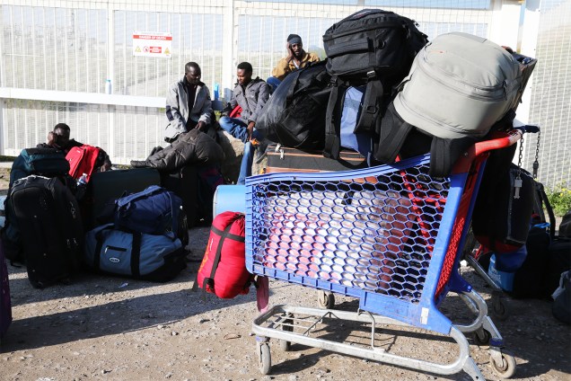 Migrantes aguardam ônibus para serem transportados para centros de acolhimento, após evacuação do acampamento de refugiados em Calais, na França - 25/10/2016
