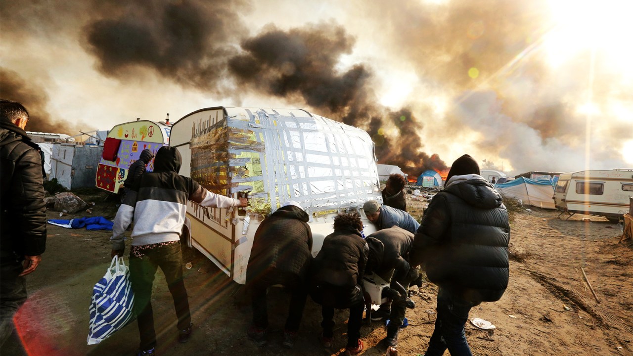Barracas são incendiadas durante o terceiro dia de evacuação do acampamento montado no campo de Calais - 26/10/2016