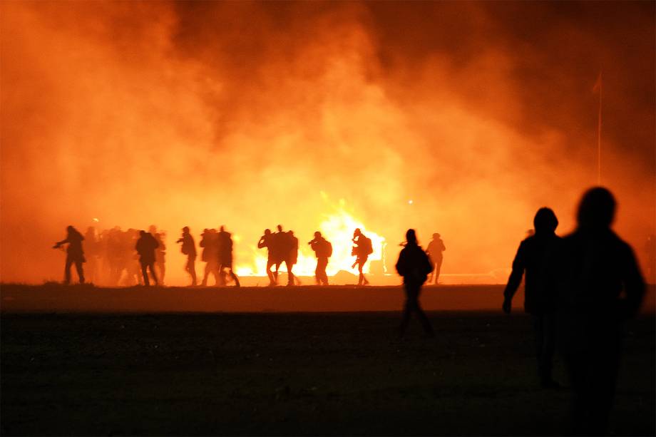 Coluna de fumaça é vista durante a evacuação de migrantes do acampamento localizado em Calais, na França - 23/10/2016