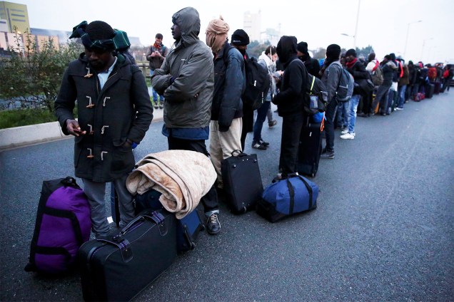 Migrantes fazem fila para serem transportados para centros de acolhimento, durante operação policial para evacuação do acampamento improvisado de refugiados na cidade de Calais, na França - 24/10/2016