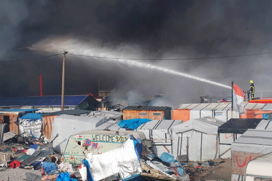 Bombeiros apagam incêndio em barracas montadas por refugiados no campo de Calais, na França - 26/10/2016