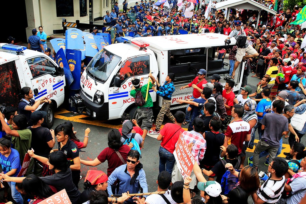 Manifestantes depredam carros policiais durante protesto contra a permanência de tropas norte-americanas nas Filipinas - 19/10/2016