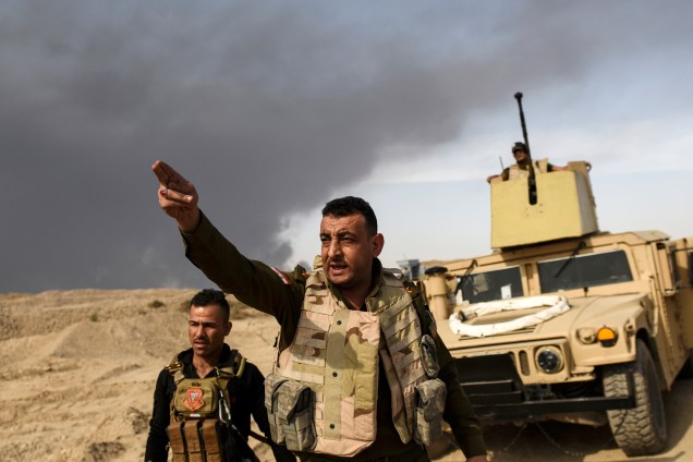 Membro das forças iraquianas orienta militares da linha de frente nos arredores da cidade de Qayyarah, sul de Mosul, durante ofensiva contra o Estado Islâmico - 16/10/2016