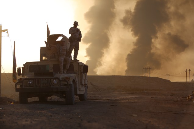 Exército iraquiano chega na vila Hut enquanto a fumaça sobe dos poços de petróleo incendiados por terroristas do Estado Islâmico para limitar o avanço das forças de coalizão em direção a Mosul - 18/10/2016