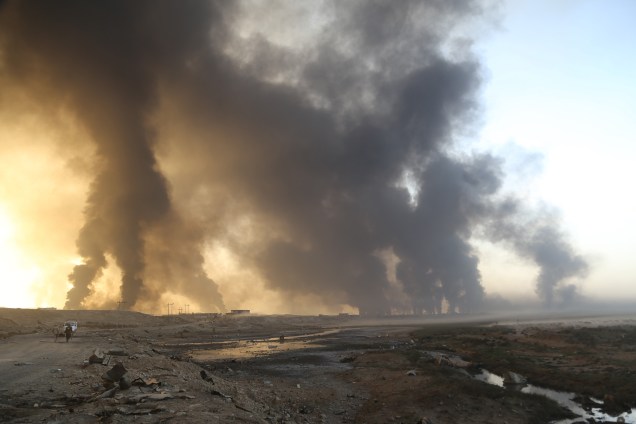 Exército iraquiano chega na vila Hut enquanto a fumaça sobe dos poços de petróleo incendiados por terroristas do Estado Islâmico para limitar o avanço das forças de coalizão em direção a Mosul - 18/10/2016