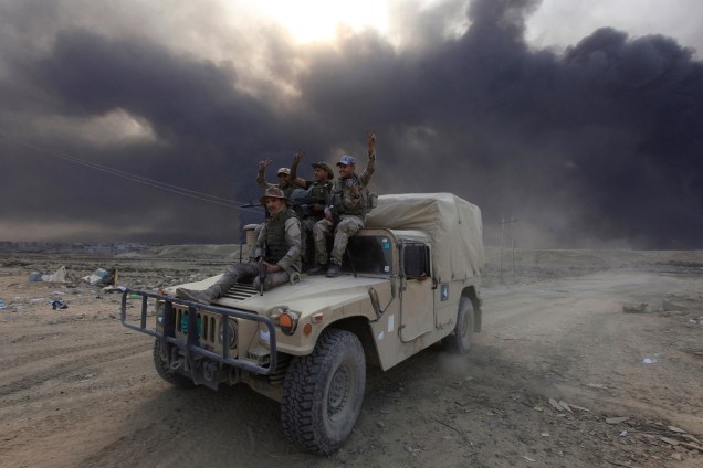Membros do Exército iraquiano posam para foto sobre um veículo militar em Qayyarah, durante uma operação contra militantes Estado islâmico em Mosul - 19/10/2016