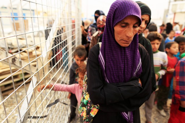 Mulher espera em fila para receber cobertores e colchões, em acampamento para desabrigados durante a ofensiva militar em Mosul, no Iraque - 24/10/2016