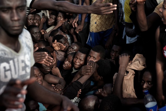 Imigrantes aguardam por resgate em uma embarcação superlotada e à deriva no Mar Mediterrâno, ao norte da costa Líbia