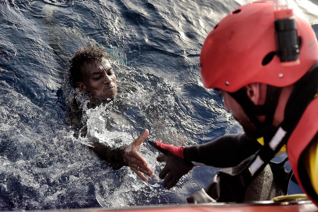 Homem é resgatado por um membro da organização humanitária Proactiva Open Arms na costa da Líbia no Mar Mediterrâneo