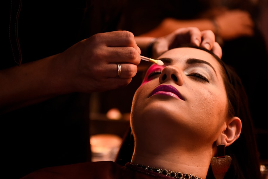 Mulher é maquiada durante a São Paulo Fashion Week