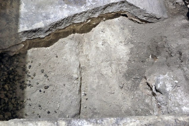 Após retiraram a primeira camada de mármore que recobria o túmulo, os arqueólogos encontraram uma pilha de entulho (foto) e uma nova pedra, com uma pequena cruz gravada. Embaixo dela estava o que, acredita-se que seja leito mortuário de Jesus.