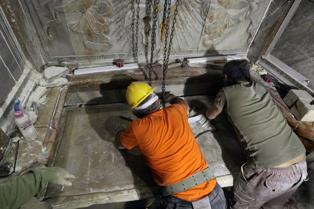 Equipe de especialistas limpa a superfície de uma das placas de mármore que cobria o local que, acredita-se, seja o túmulo de Jesus.