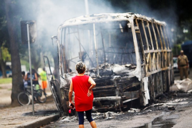 Mulher observa ônibus queimado durante protesto de servidores públicos em frente à Alerj - 16/11/2016