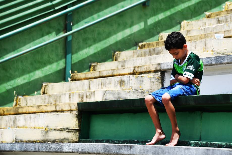 Torcedor mirim da Chapecoense senta sozinho nas arquibancadas da Arena Condá em Chapecó (SC) , durante homenagens às vítimas do acidente aéreo na Colômbia