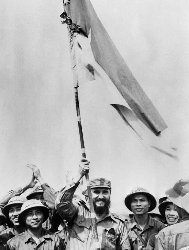 Fidel Castro levanta a bandeira do Vietnã durante visita ao país enquanto ocorria a guerra do Vietnã contra os Estados Unidos, em 1973