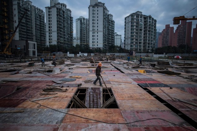 Homem trabalha em um canteiro de obras de um edifício residencial em Xangai, na China - 29/11/2016
