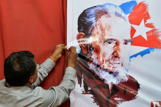 Membro do Partido Comunista da Índia pendura uma imagem do ex-ditador cubano Fidel Castro durante uma reunião  em Bangalore - 28/11/2016