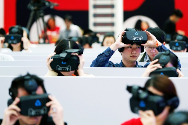 Repórteres testam óculos de realidade virtual durante a 'Black Friday' chinesa, promovida pela empresa de e-commerce Alibaba Group, na cidade de Shenzhen - 11/11/2016