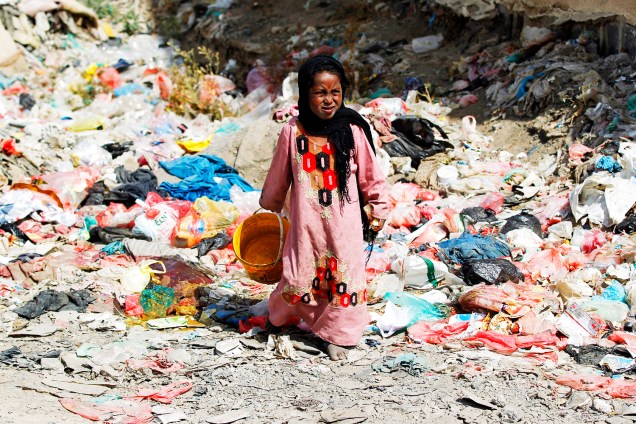 Garota da comunidade de Al-Akhdam anda sobre lixo em uma favela em Sanaa, capital do Iêmen 09/11/2016