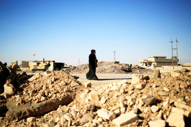 Mulher caminha próxima a um posto de controle de militares iraquianos no leste de Mosul, durante ofensiva militar contra o grupo extremista Estado Islâmico - 03/11/2016
