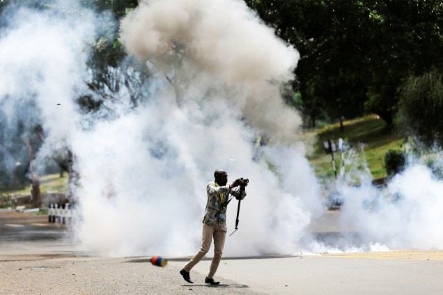 Jornalista corre após policiais jogarem bombas de gás lacrimogêneo para dispersar manifestantes, em protesto contra a corrupção na cidade de Nairobi, no Quênia - 03/11/2016