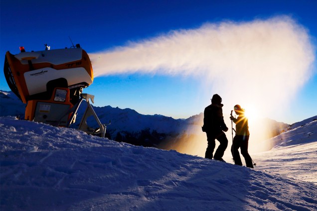 Esquiadores verificam máquina de neve artificial em resort de Verbier, na Suíça - 28/11/2016