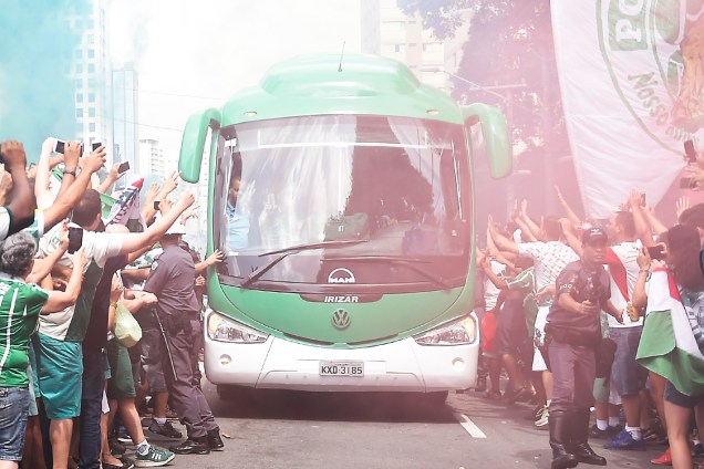 Torcedores do Palmeiras acompanham a chegada do ônibus da equipe ao estádio, em São Paulo