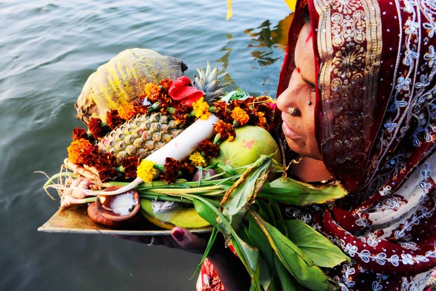 Devota hindu é vista com oferendas em adoração à divindade do sol 'Surya', em um lago de Bhopal, na India, durante o festival religioso 'Chhath Puja' - 06/11/2016