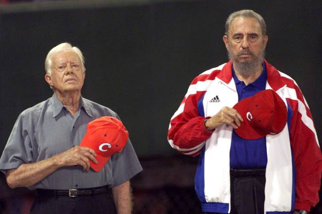 O ex-presidente norte-americano Jimmy Carter e o então ditador cubano Fidel Castro ouvem o hino nacional cubano no estádio de beisebol "Latinoamericano" em Havana em maio de 2002
