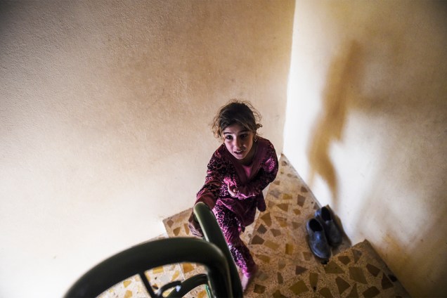Garota iraquiana é vista na escadaria de uma mesquita onde civis estão se refugiando na vila de Gogjali, em Mosul - 02/11/2016