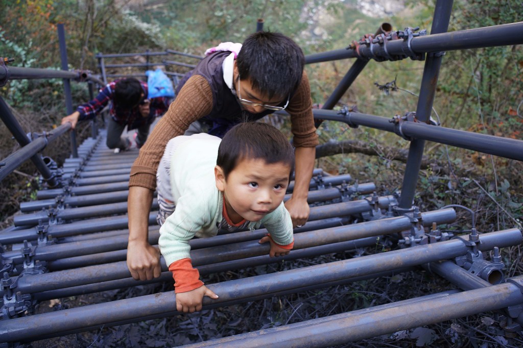 Crianças sobem penhasco para ir para escola na China