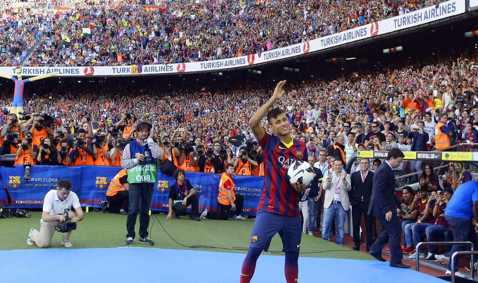 Neymar waves to Barcelona's supporters at his presentation after signing a five-year contract with the club, at Nou Camp stadium in Barcelona